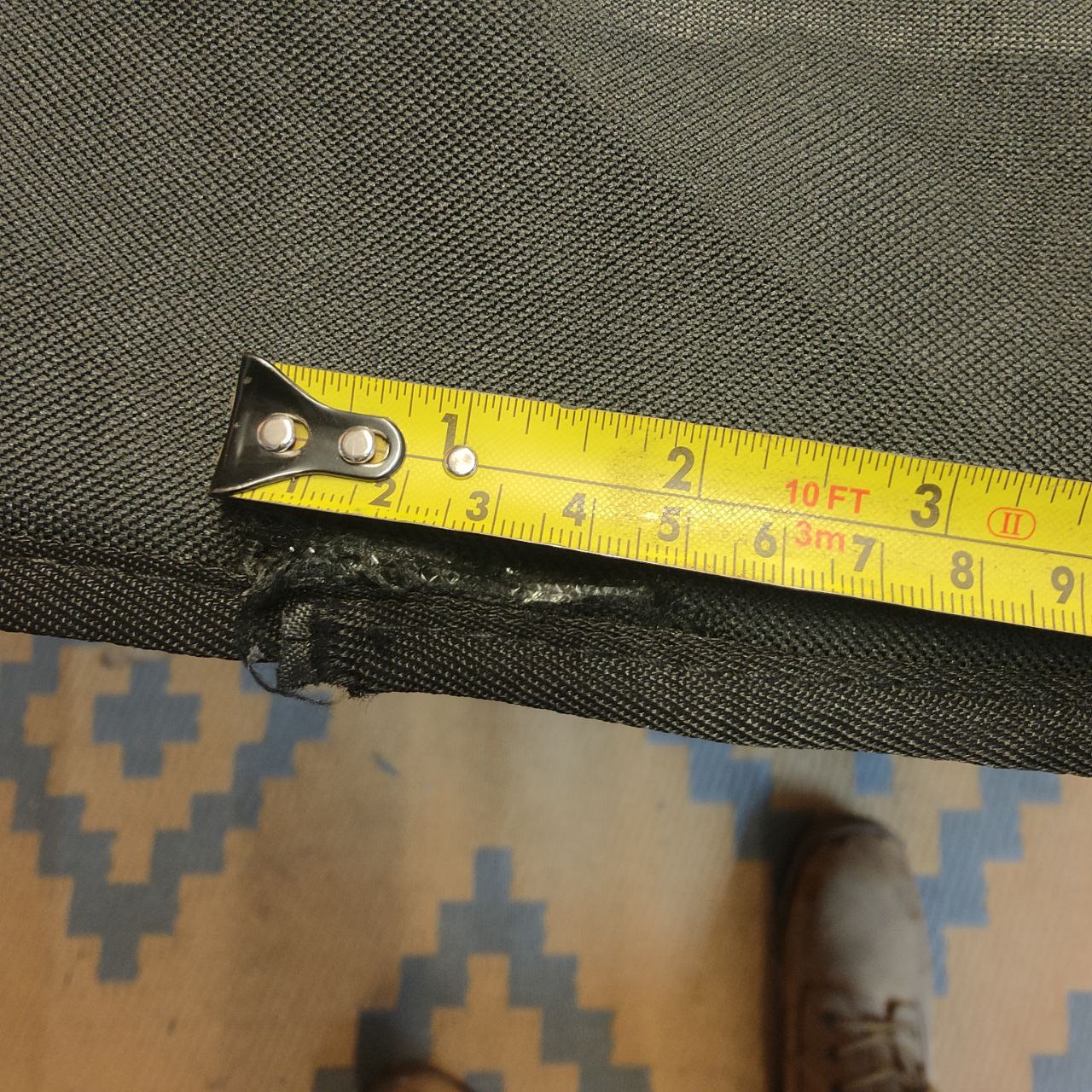 Yellow measuring tape on a dark gray fabric surface