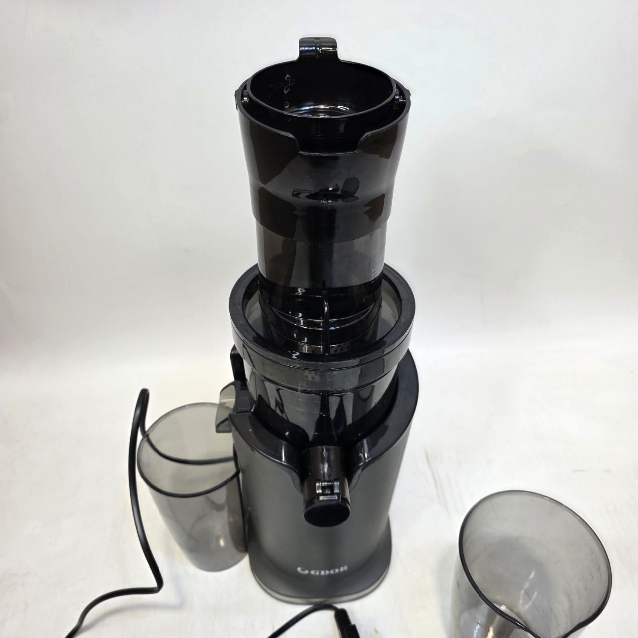 Black juicer with two clear juice cups on a white background