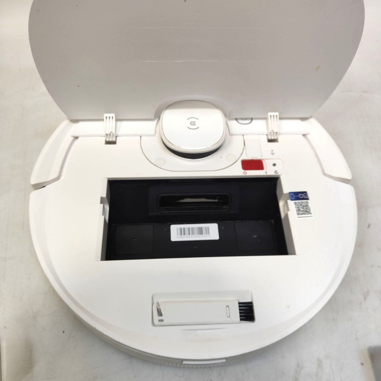 White electronic device with a black tray on a light gray background