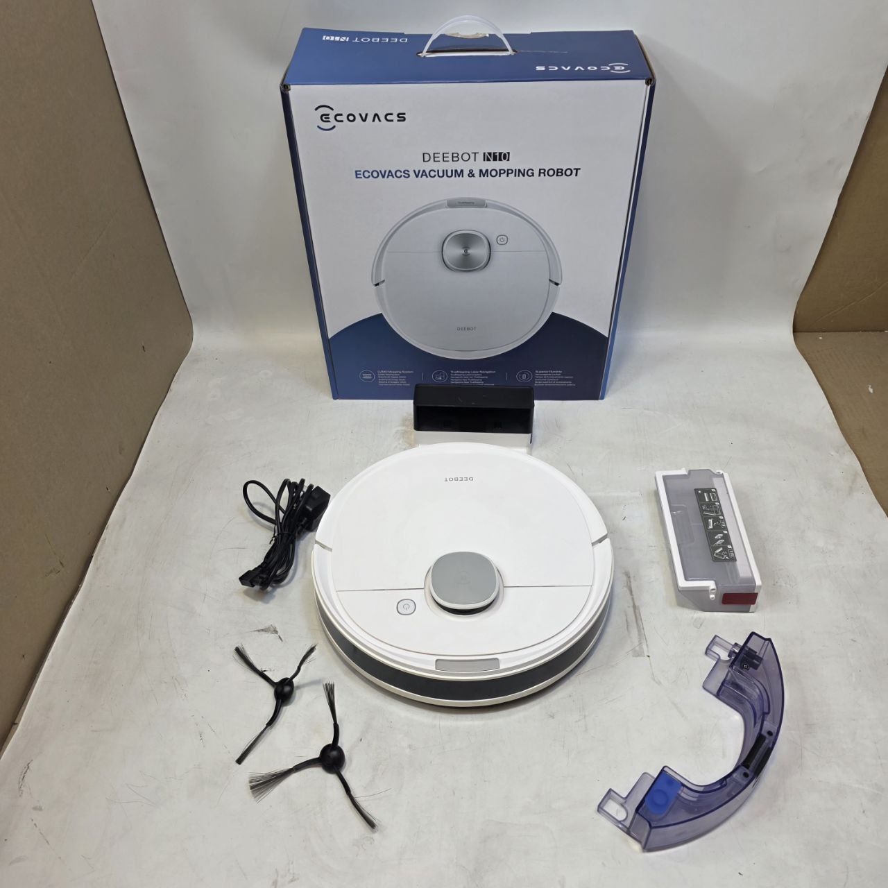Ecovacs Deebot vacuum and mopping robot with accessories on a white surface
