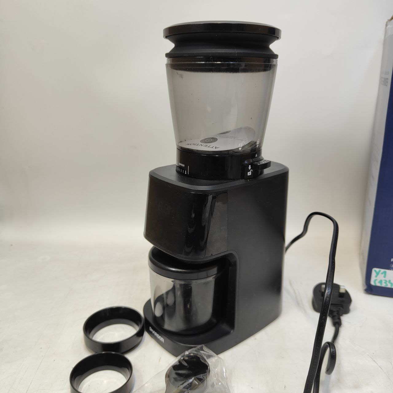Black coffee grinder with clear container on a white surface