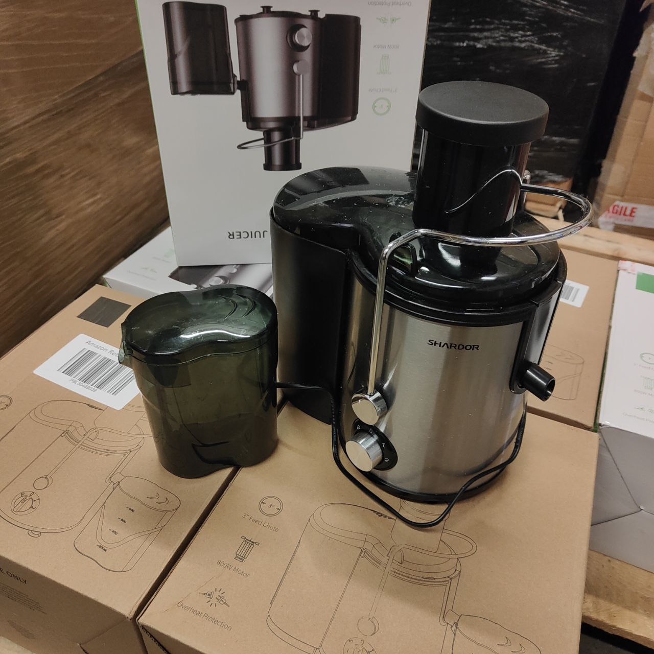 Shandor juicer on a cardboard box with packaging in the background