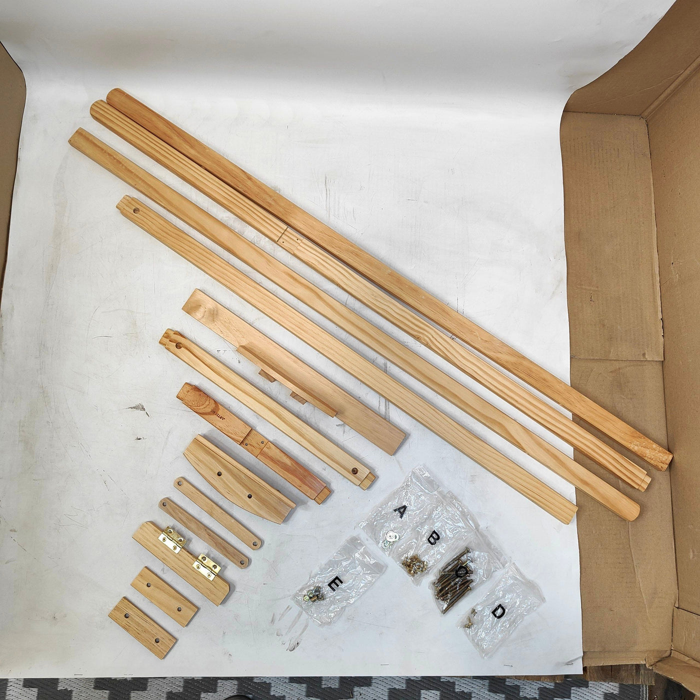 Wooden furniture assembly parts and hardware on a white surface