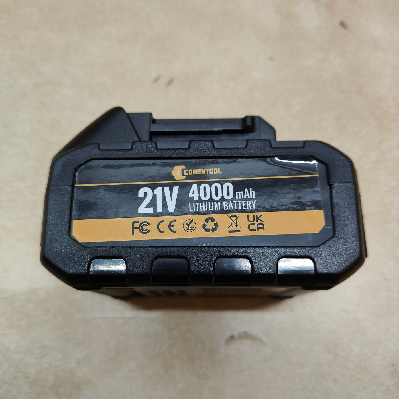 Black and gold battery pack with 'Conentool' branding on a beige surface