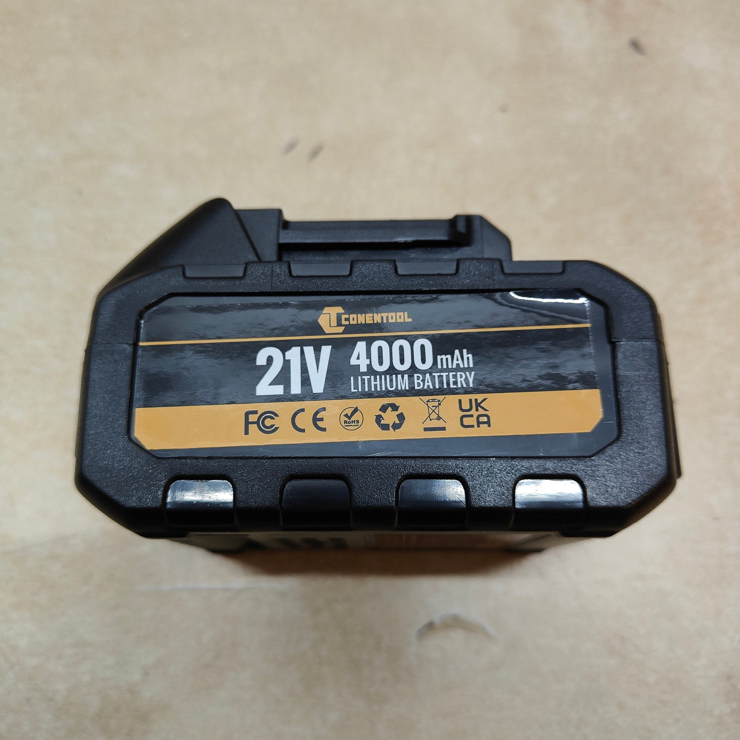 Black and gold battery pack with 'Conentool' branding on a beige surface