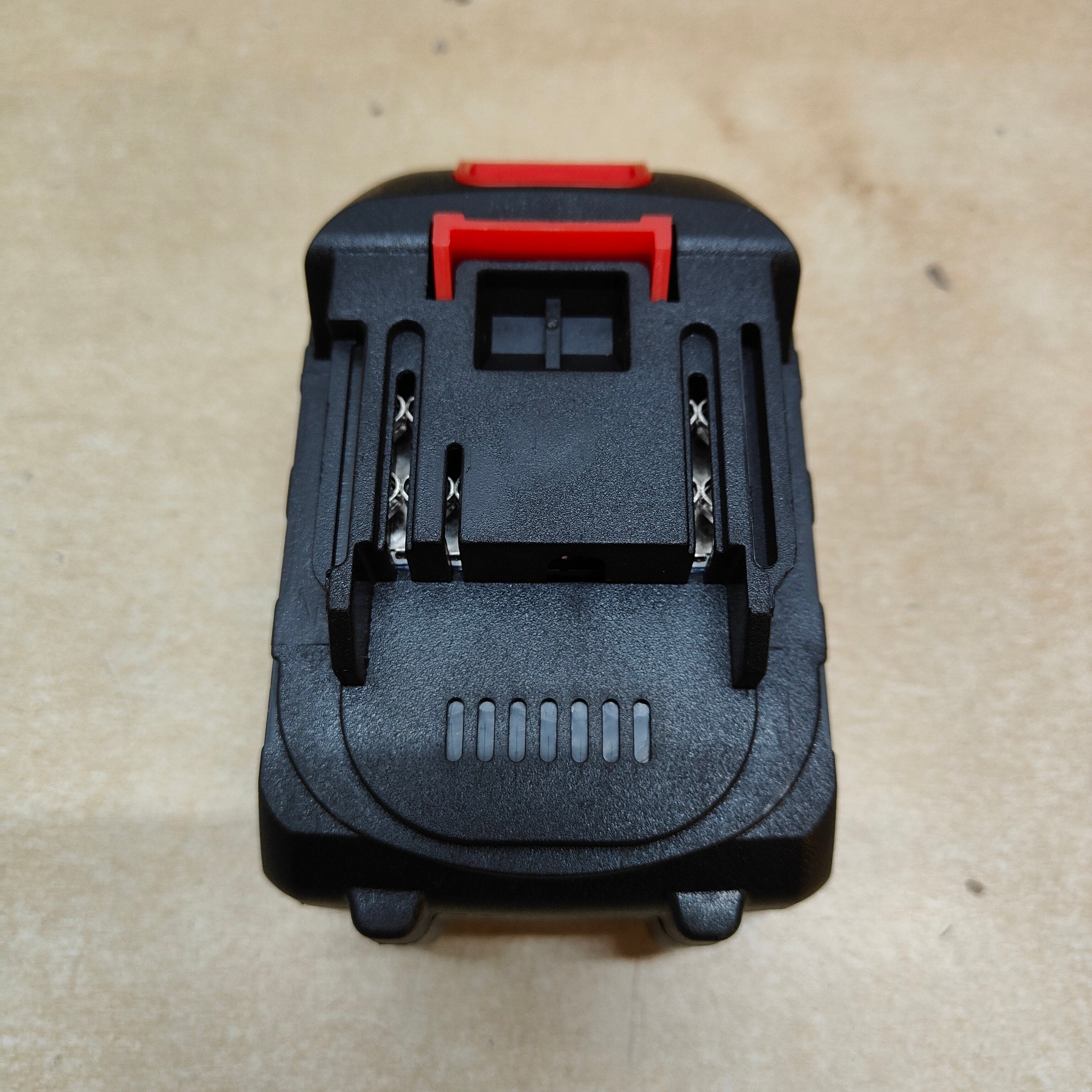 Black and red tool attachment on a beige background