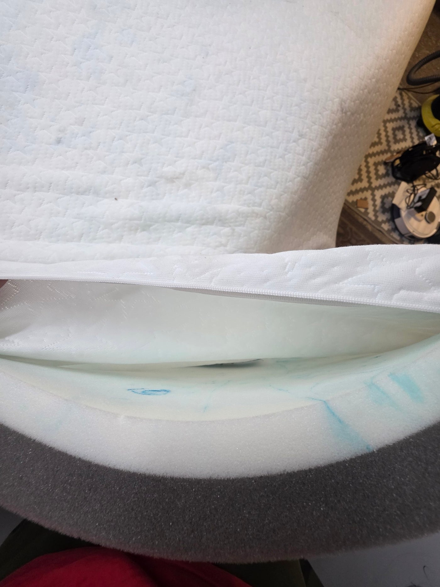 Close-up of a white mattress with a textured surface and visible stitching.
