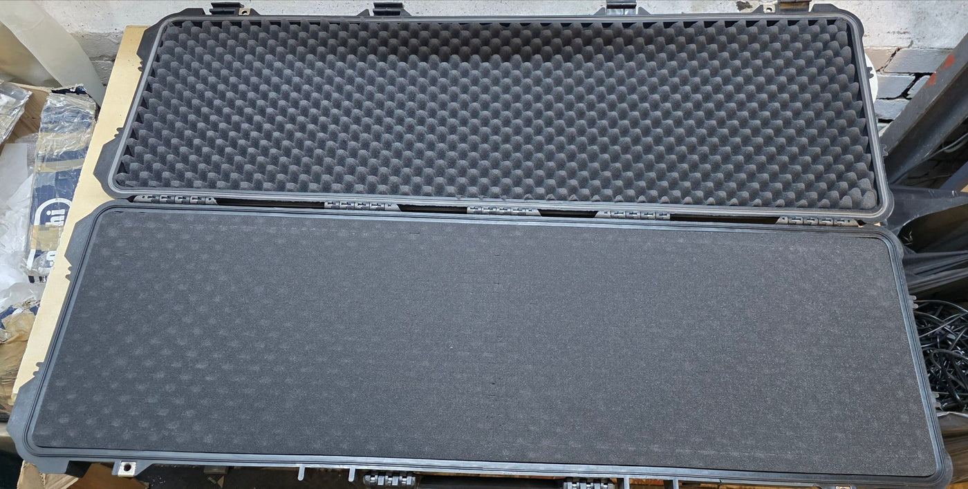 Large black foam-lined case on a wooden surface