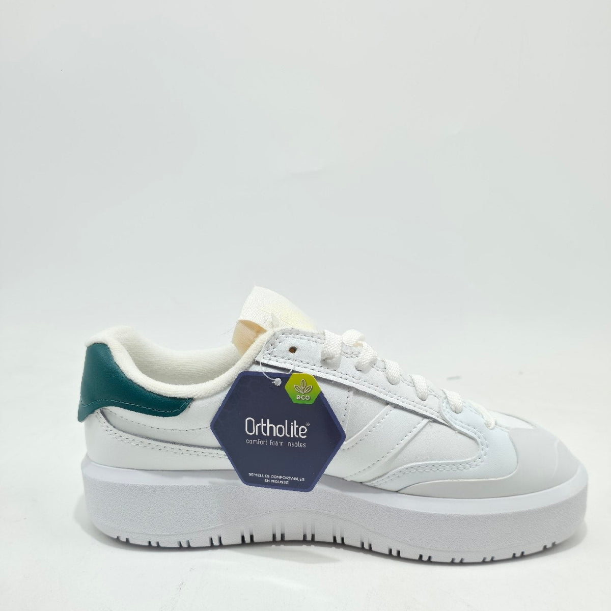 A white low-top athletic sneaker with a dark green heel accent, white laces, and a dark blue Orthofe brand tag attached near the collar, set against a plain white background.
