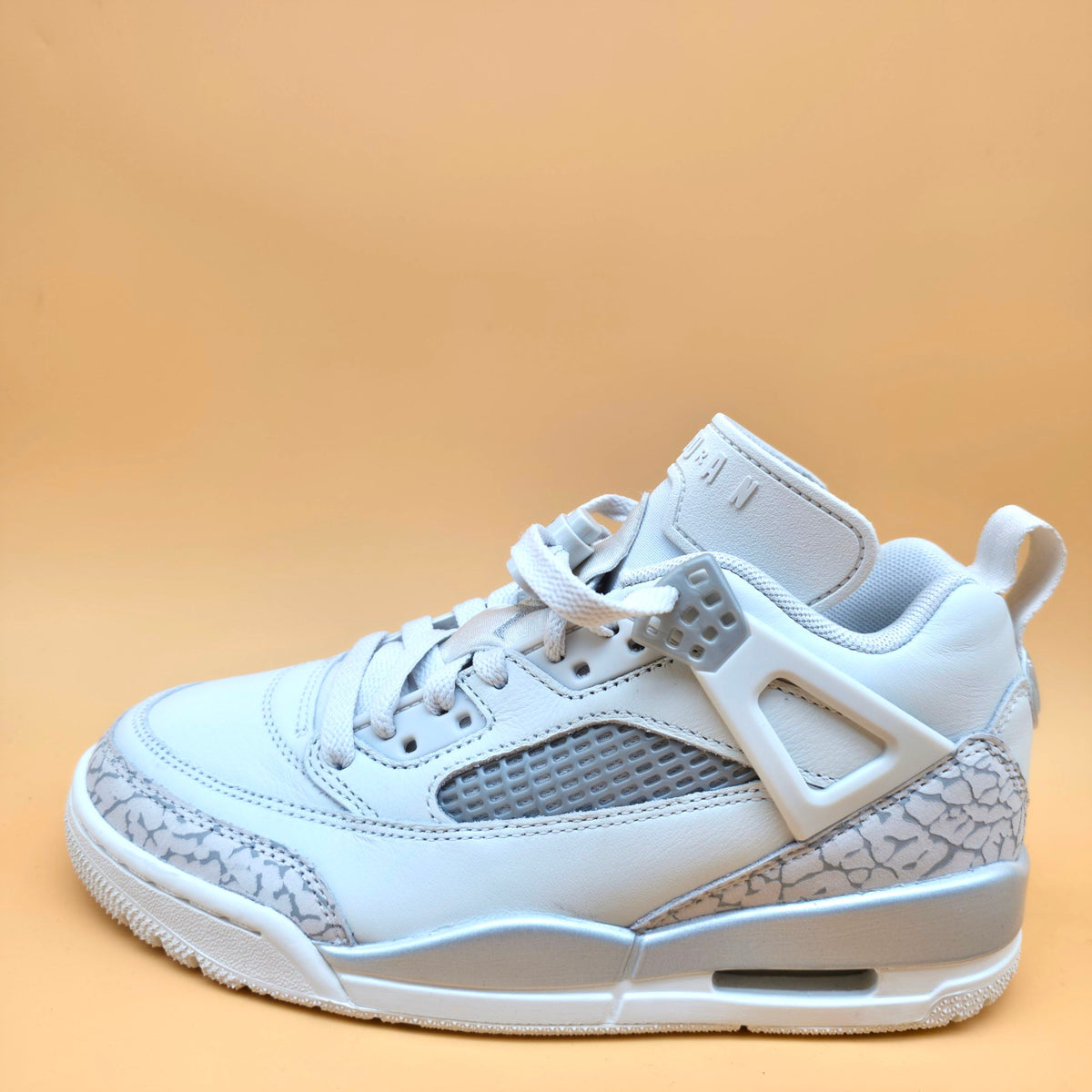 A light gray and white Air Jordan 3 Retro Low sneaker with gray elephant print overlays, shown from a side profile on a solid beige background.