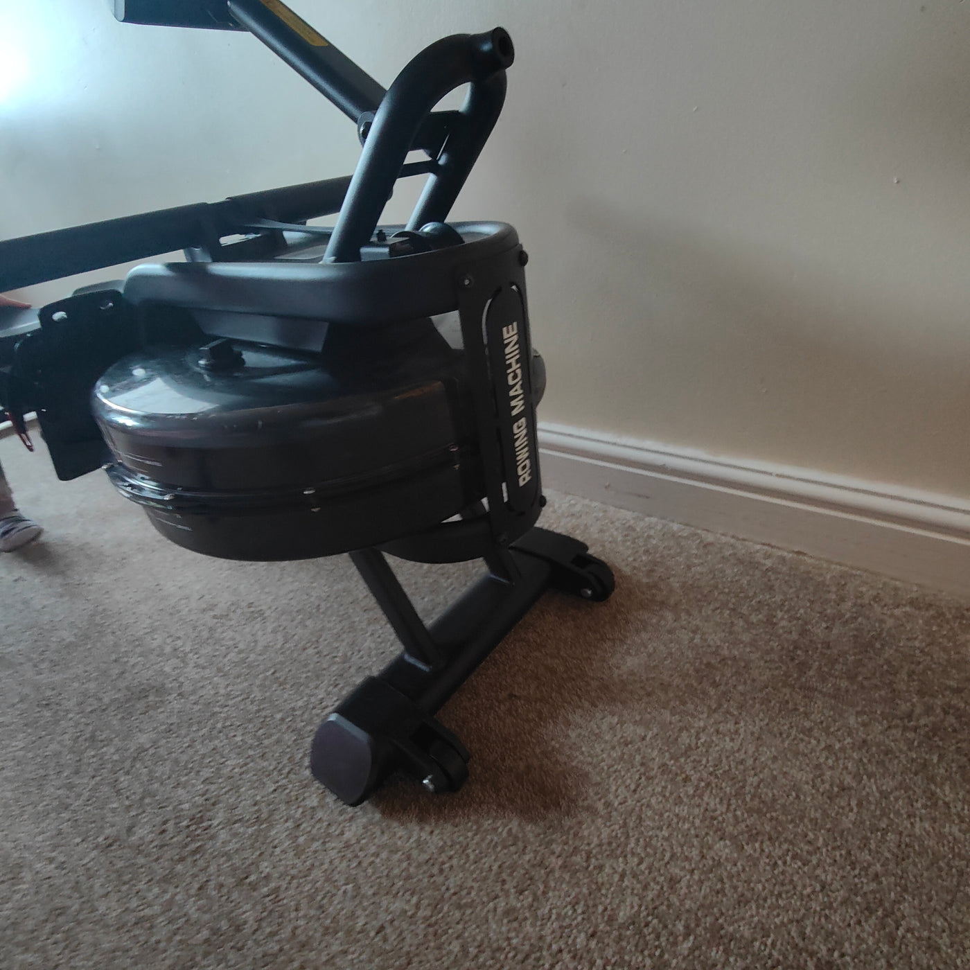 Rowing machine on a carpeted floor against a plain wall