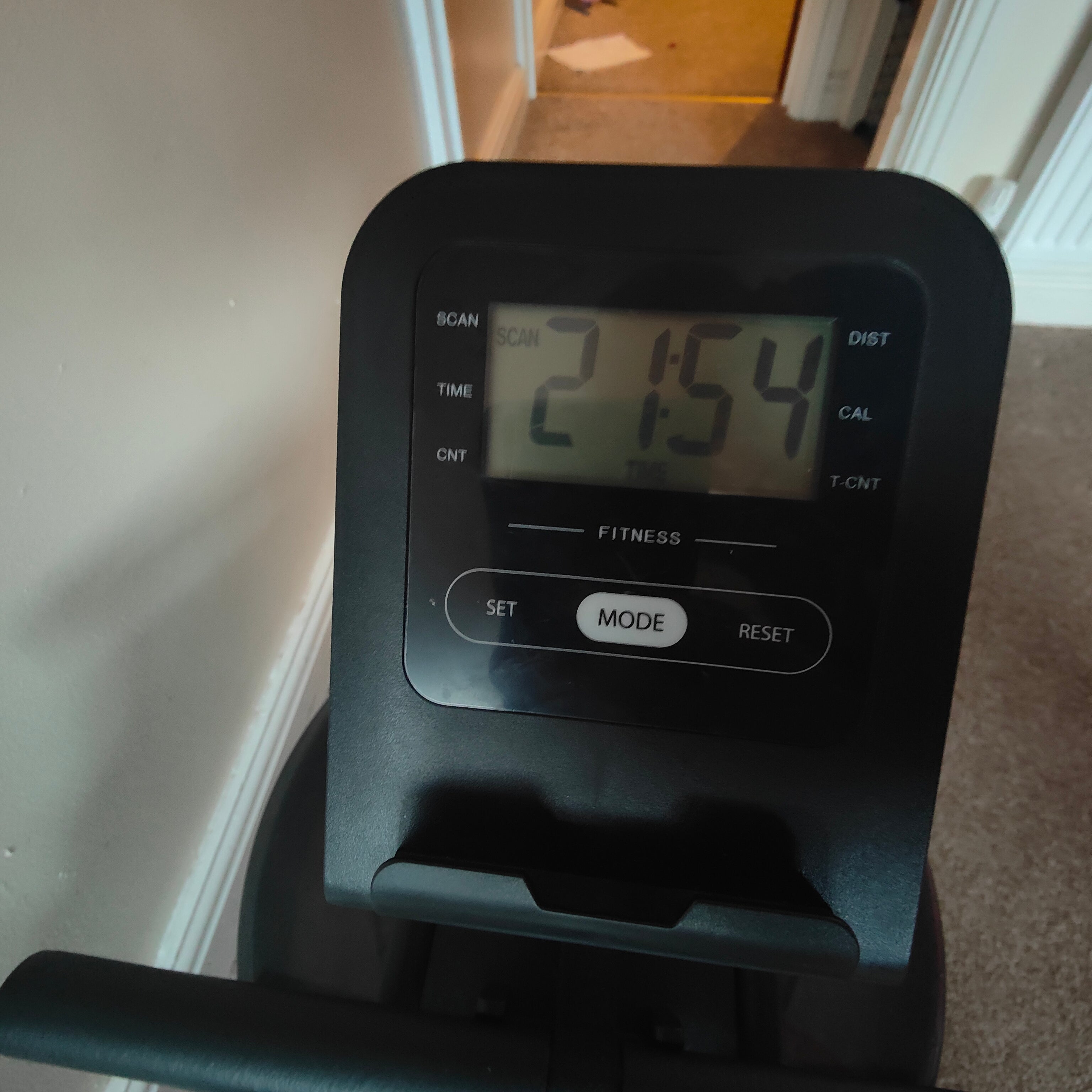 Digital display on a piece of exercise equipment showing time '21:54'.