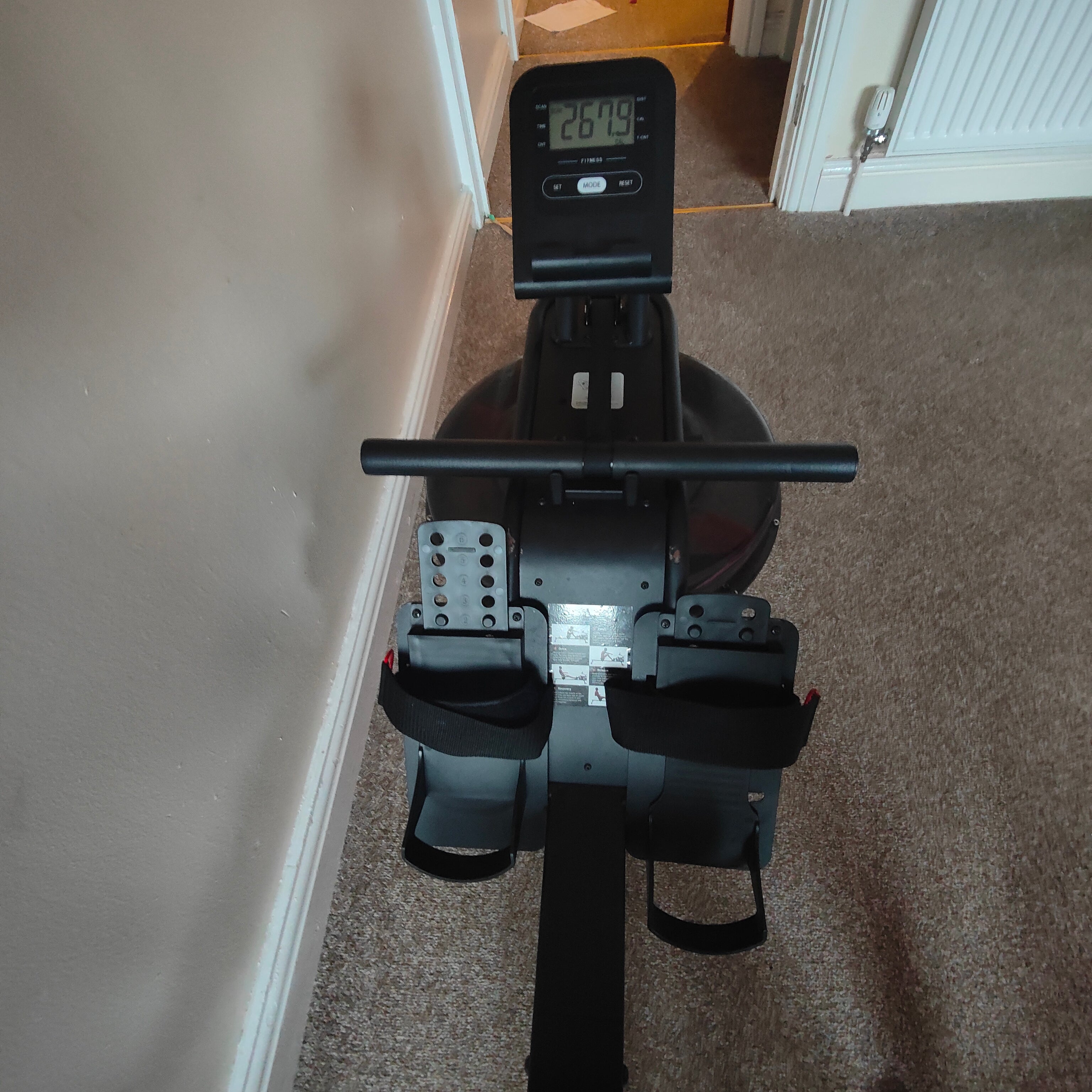 Rowing machine on a carpeted floor with digital display