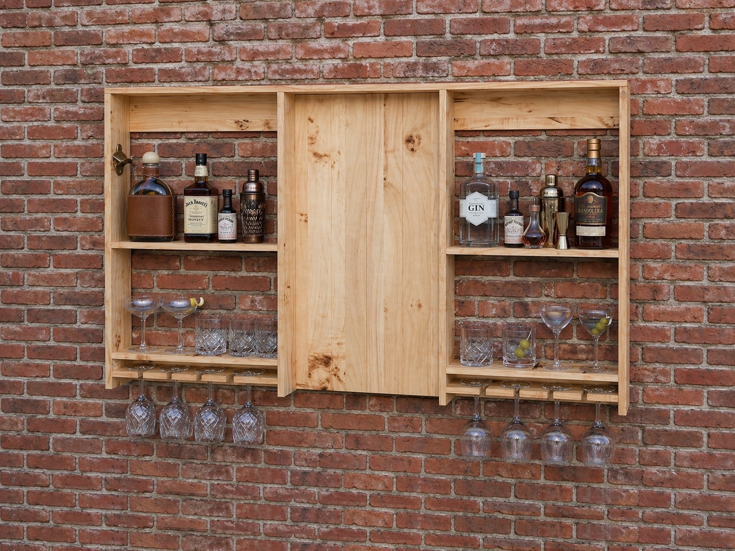 Wooden wall-mounted bar cabinet with bottles and glasses against a brick wall.