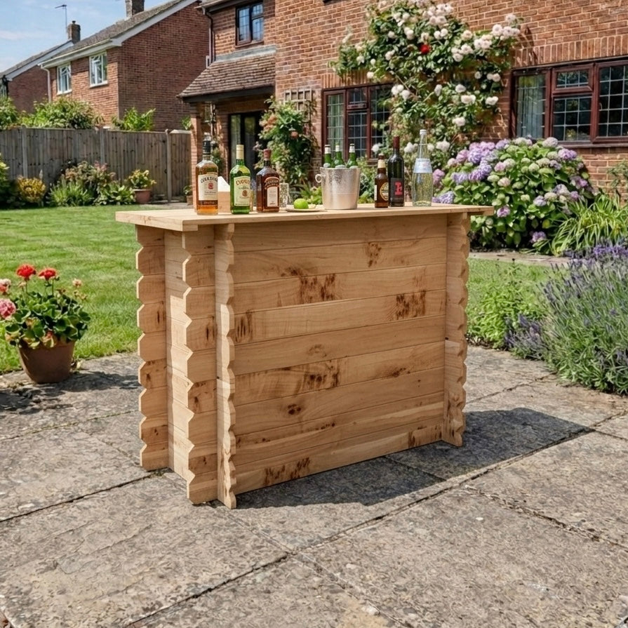 Wooden outdoor bar set up in a garden with drinks and flowers.